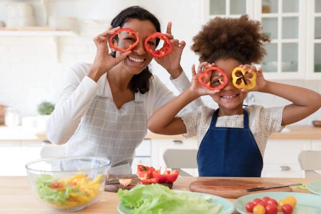 Mother and girl playing with sliced bell peppers