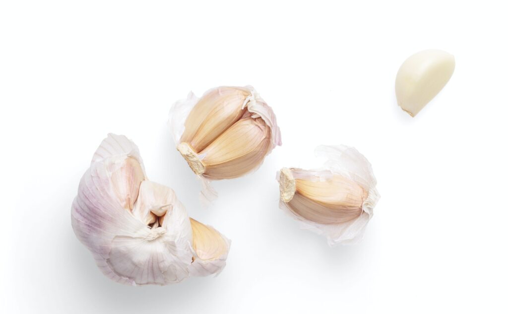 Cloves of garlic and half of a bulb of garlic
