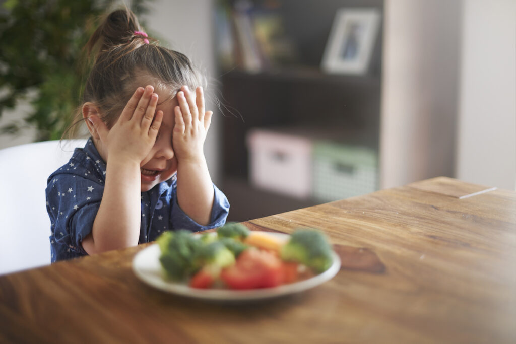 Child hiding from food, representing childhood food neophobia