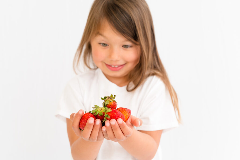 Child holding strawberries