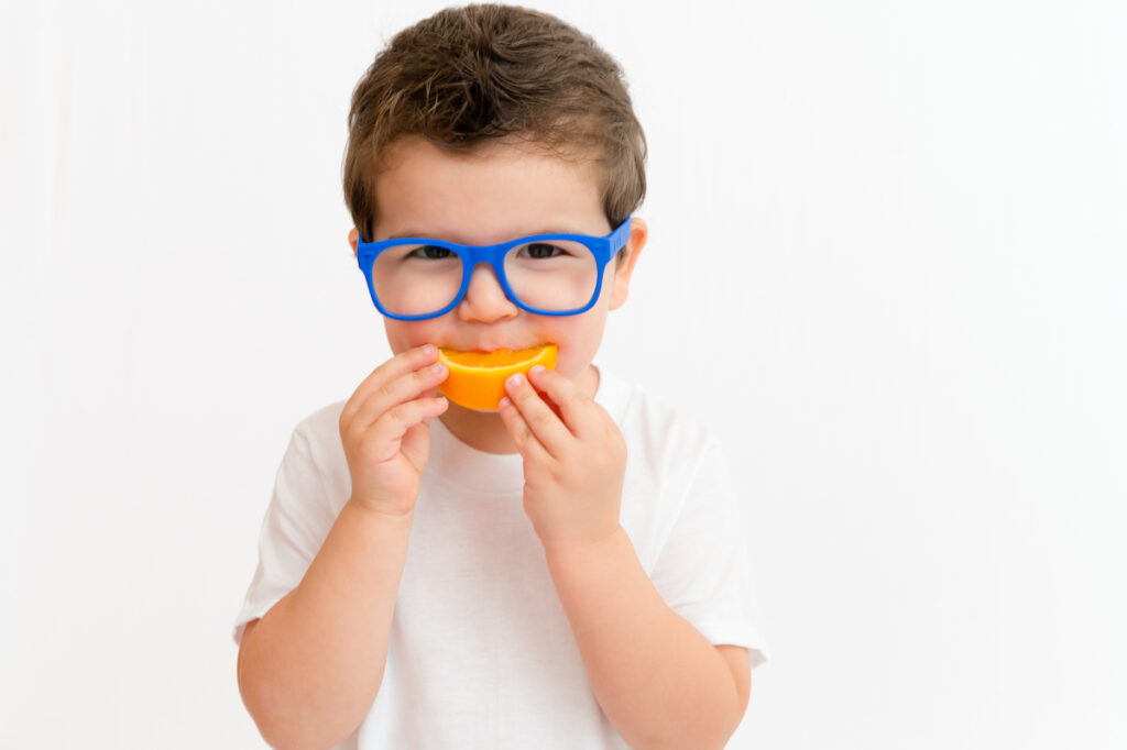 Child eating slice of orange