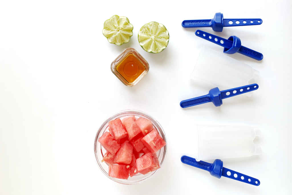 Watermelon ice pop ingredients on white with popsicle molds
