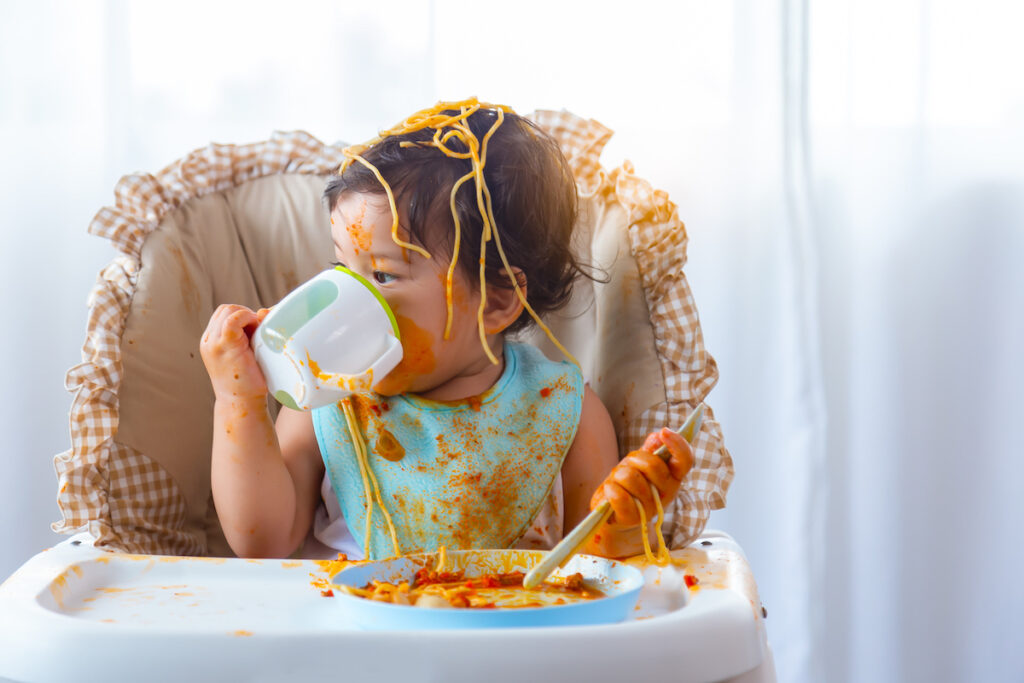 Messy eater child in high chair