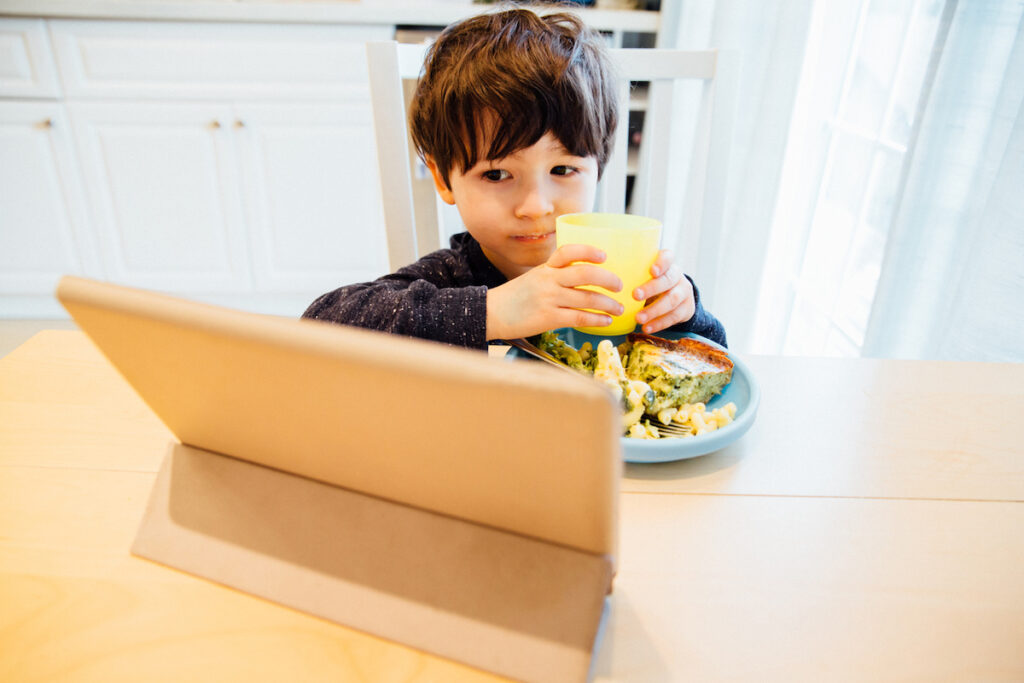 Toddler having screen time while eating a meal