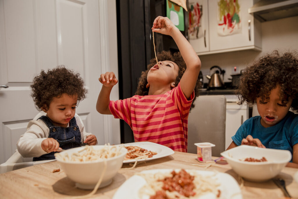 Three distracted toddlers sitting at a table