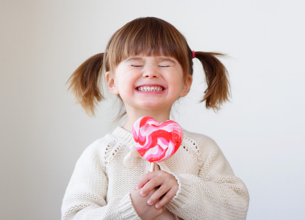 Girl holding a sugar-filled lollipop