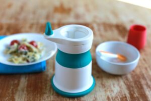 A baby food grinder with bowls of puree
