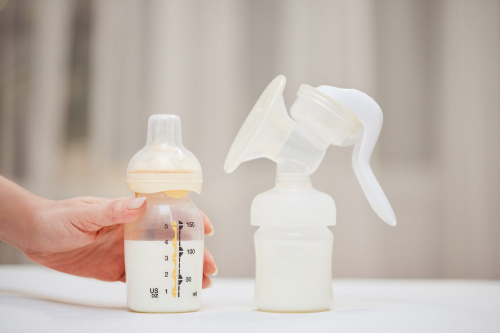 Manual breast pump and bottle with pumped breast milk