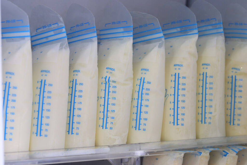 Single line of frozen pumped breast milk in storage bags in the freezer