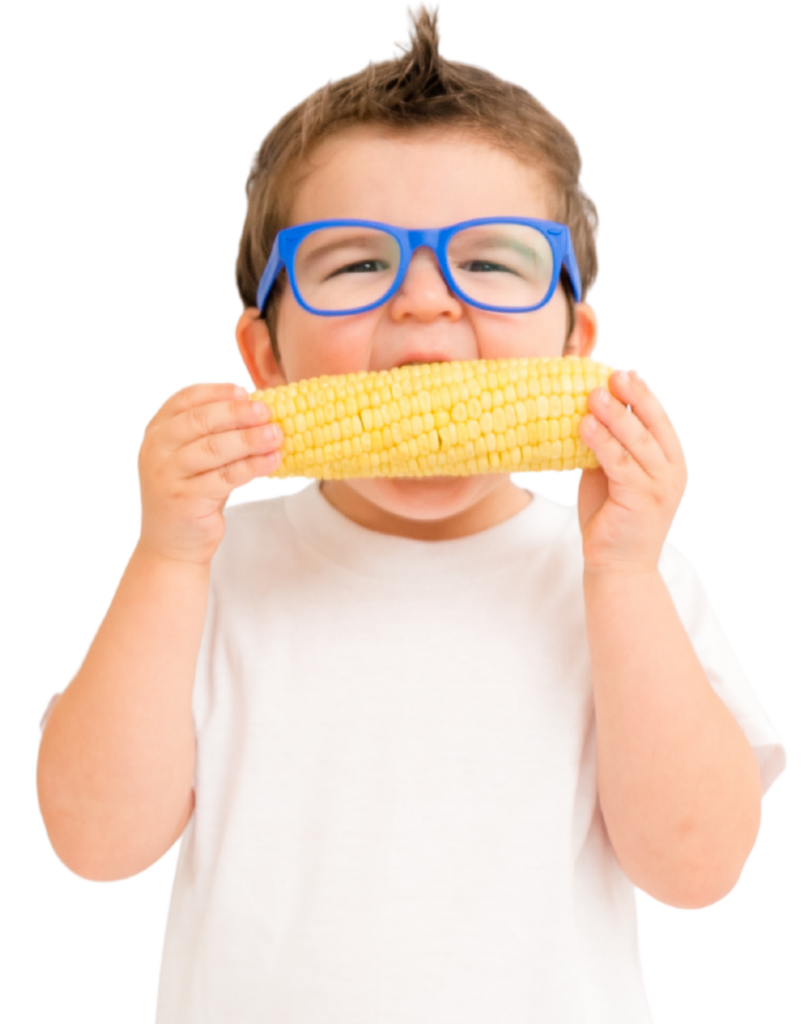 Smiling toddler eating corn on the cob, supported by the BetterBites picky eating program for kids